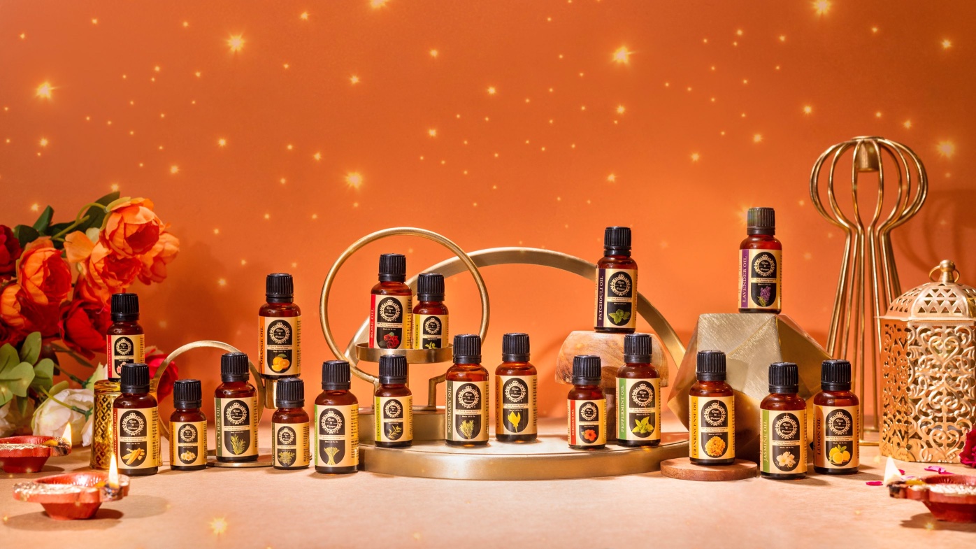 Collection of essential oil bottles arranged on a display with decorative elements in the background.