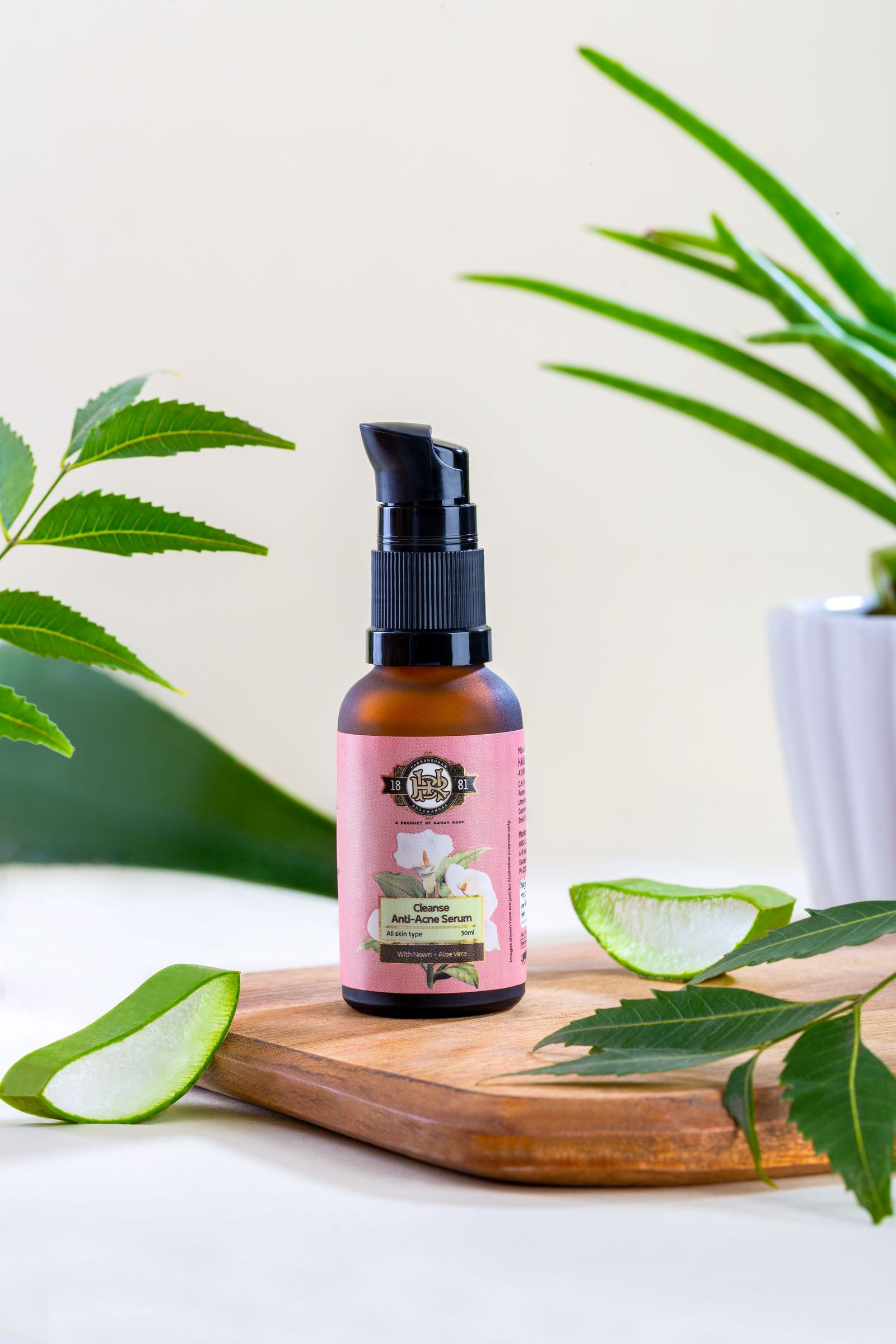 Bottle of anti-acne serum with a pump dispenser placed on a wooden surface with aloe vera leaves.