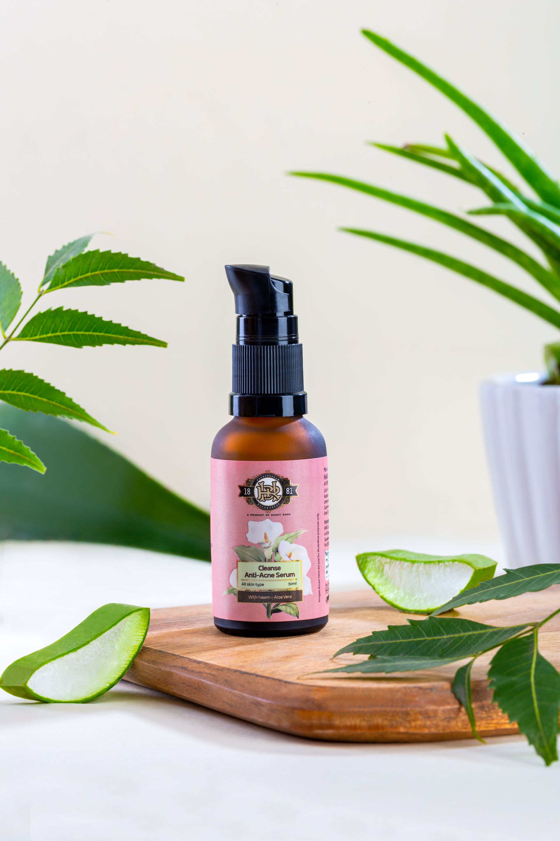 Bottle of anti-acne serum with a pump dispenser placed on a wooden surface with aloe vera leaves.