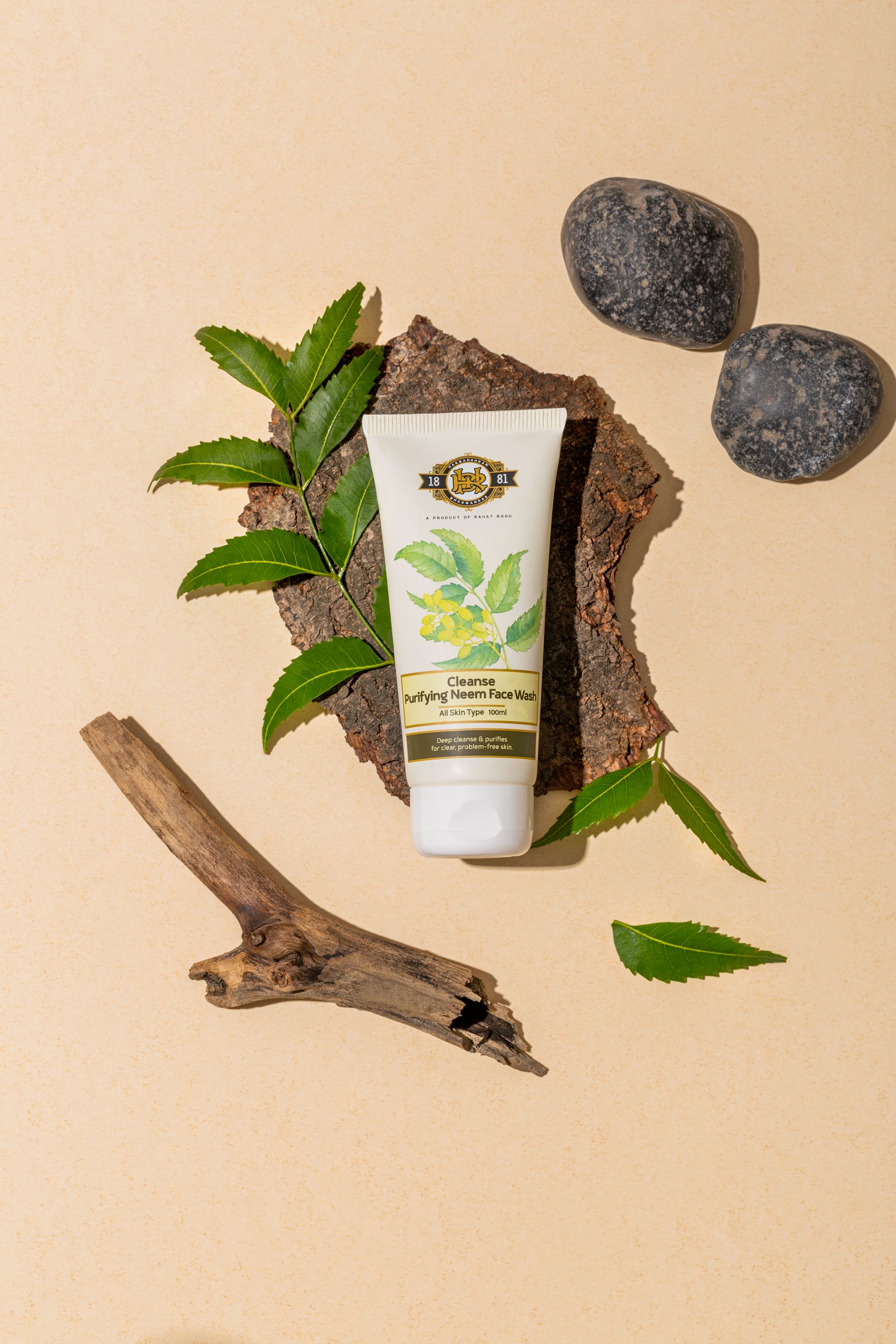 Tube of purifying neem face wash placed on a textured surface with leaves and stones.