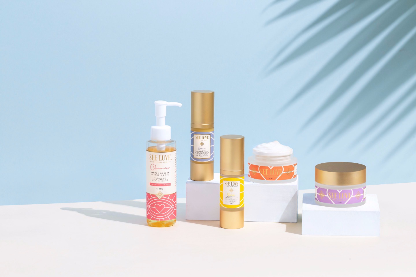 Four skincare products displayed on a light background, including a cleanser, serum, and cream.