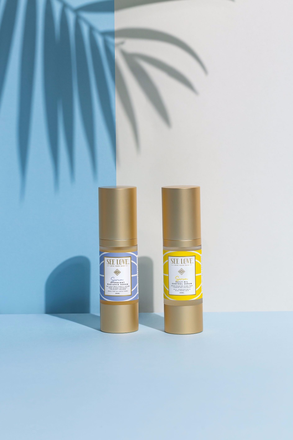 Two skincare product bottles with gold caps, one blue and one yellow, on a blue background with a shadow.
