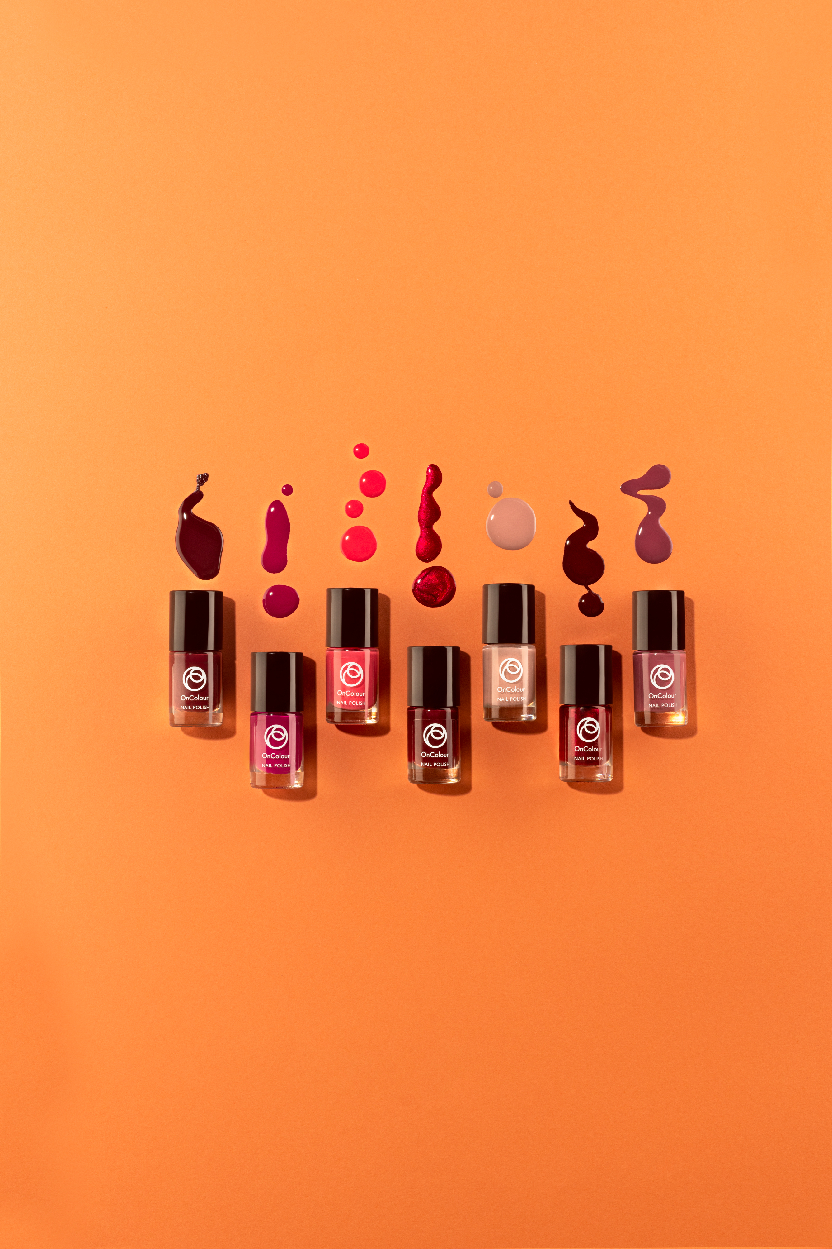 Eight nail polish bottles arranged in a row with corresponding color swatches on an orange background.