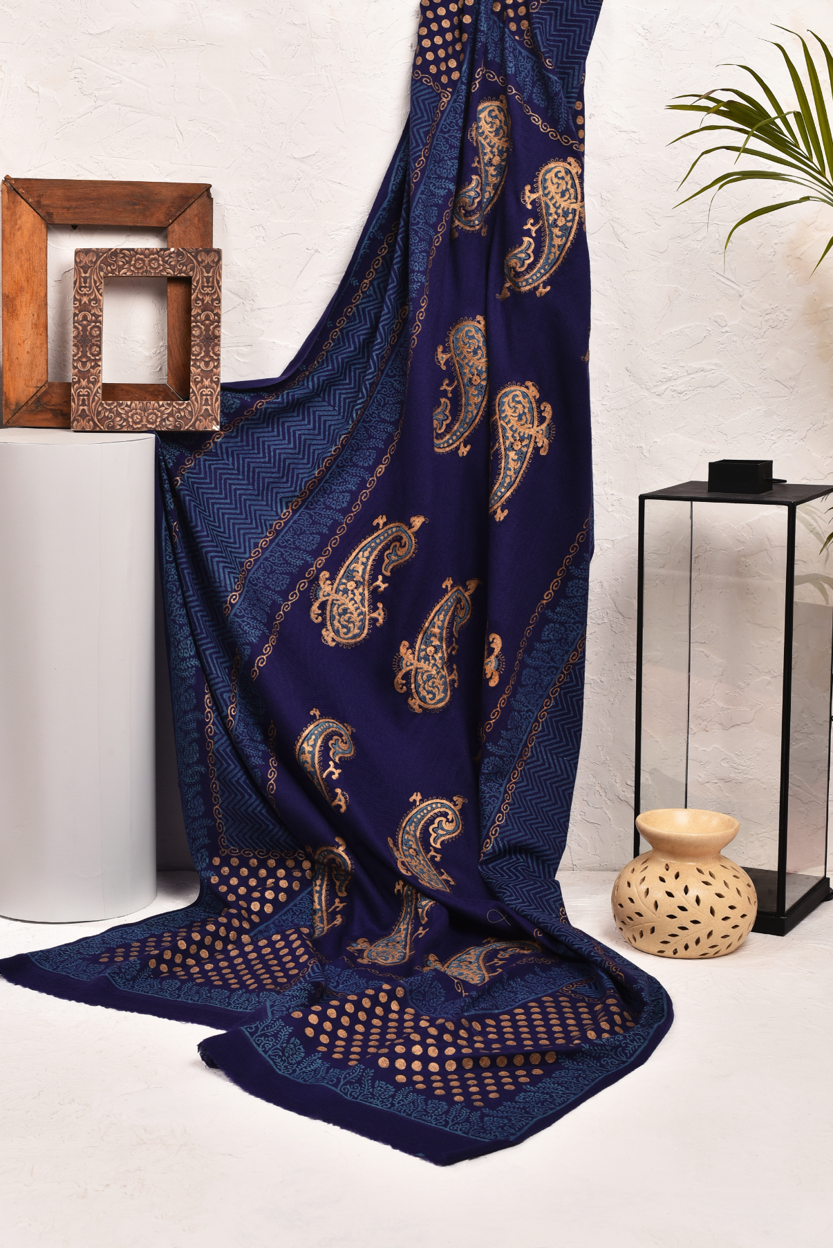 Navy blue fabric with paisley patterns and gold accents draped elegantly.