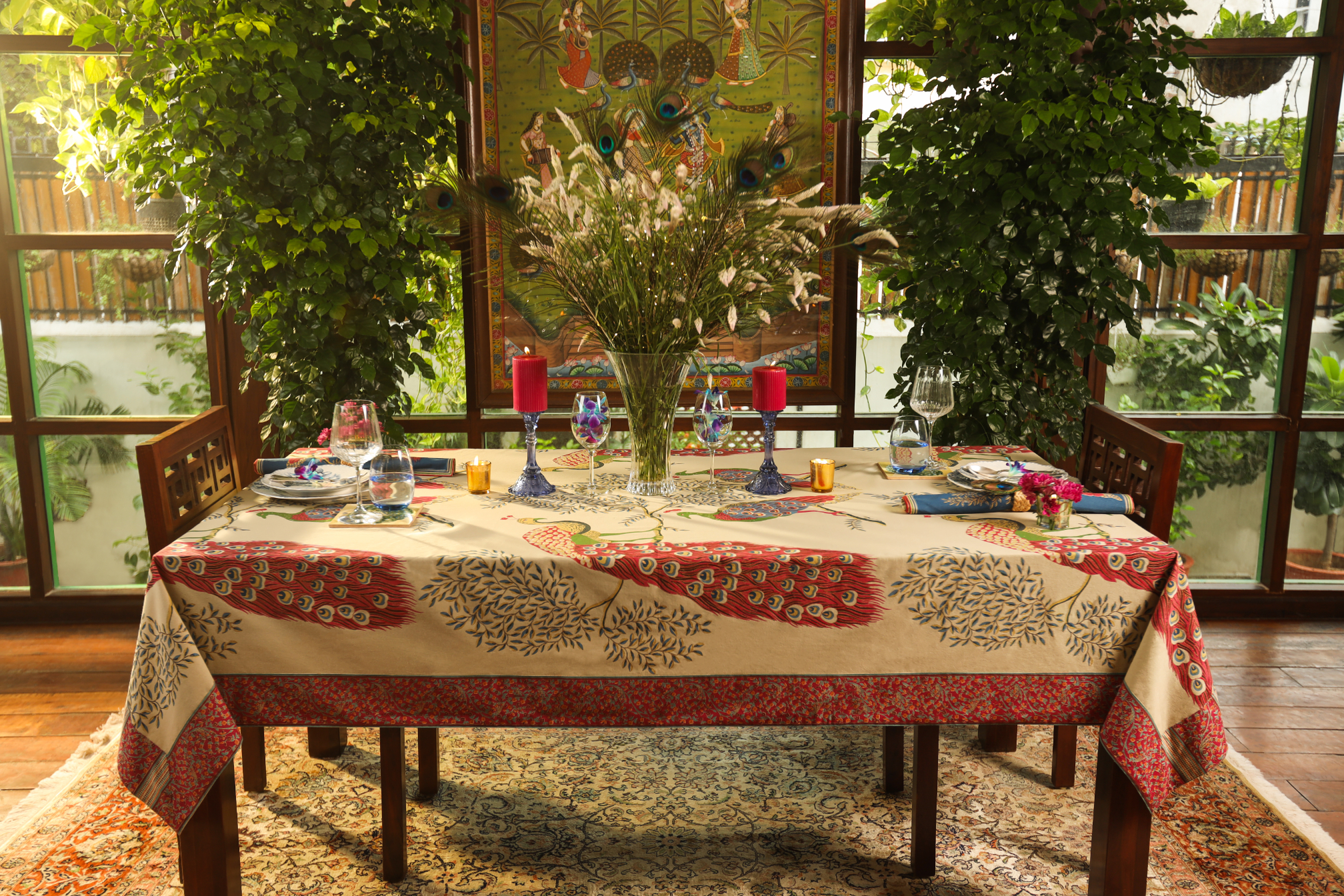 Beautifully arranged dining table with floral centerpiece, tableware, and decorative elements in a lush indoor setting.