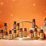 Various bottles of essential oils arranged on a display with a warm background.