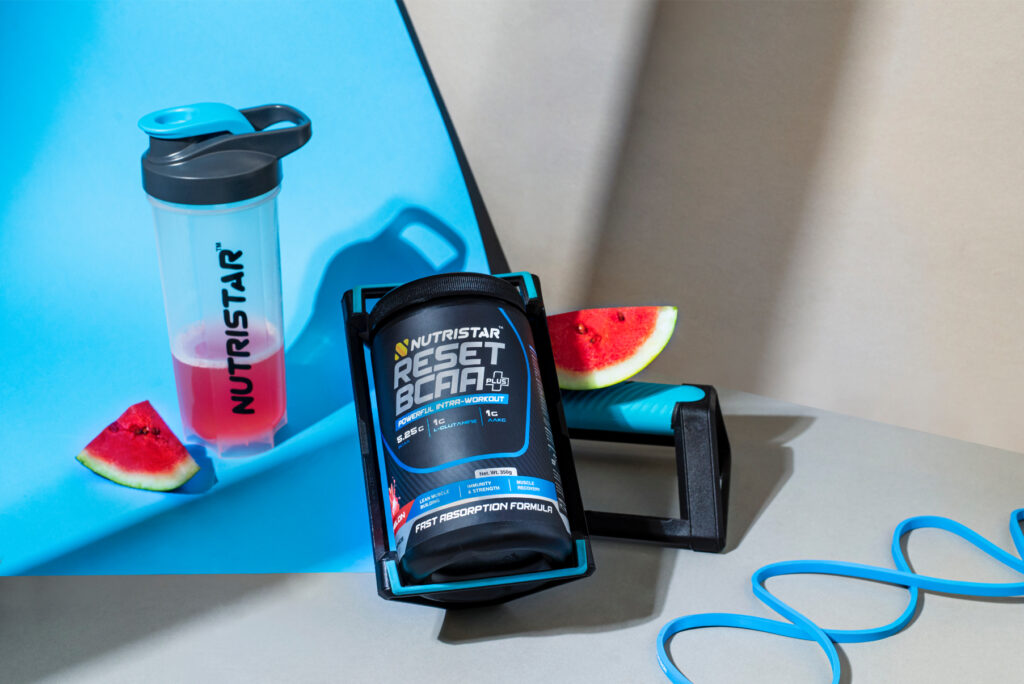Nutristar Reset BCAA supplement package with a shaker and workout accessories on a blue background.