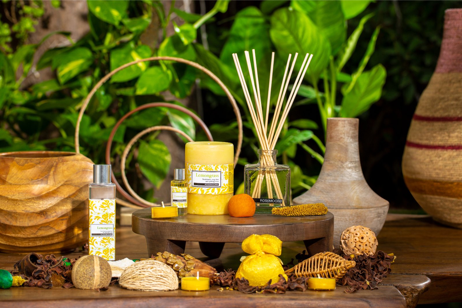 Aromatic candle, diffuser, and natural decor elements arranged on a wooden display.