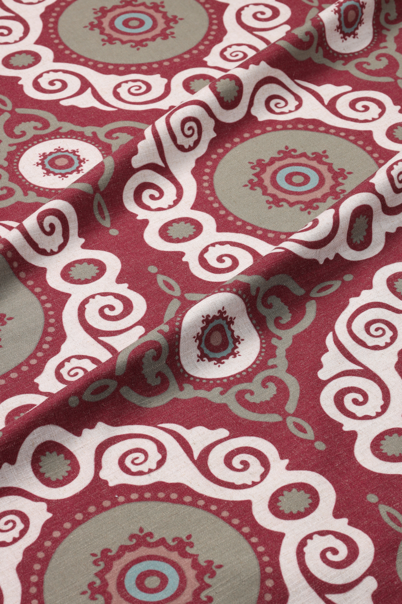 Fabric featuring a circular pattern in maroon, green, and white colors.